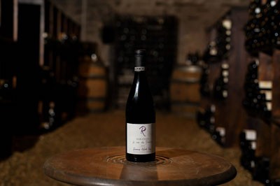 A bottle of Maranges wine featured on a table in a wine cellar.