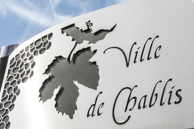 A sign engraved with grapes and leaves reading 'Ville de Chablis'.